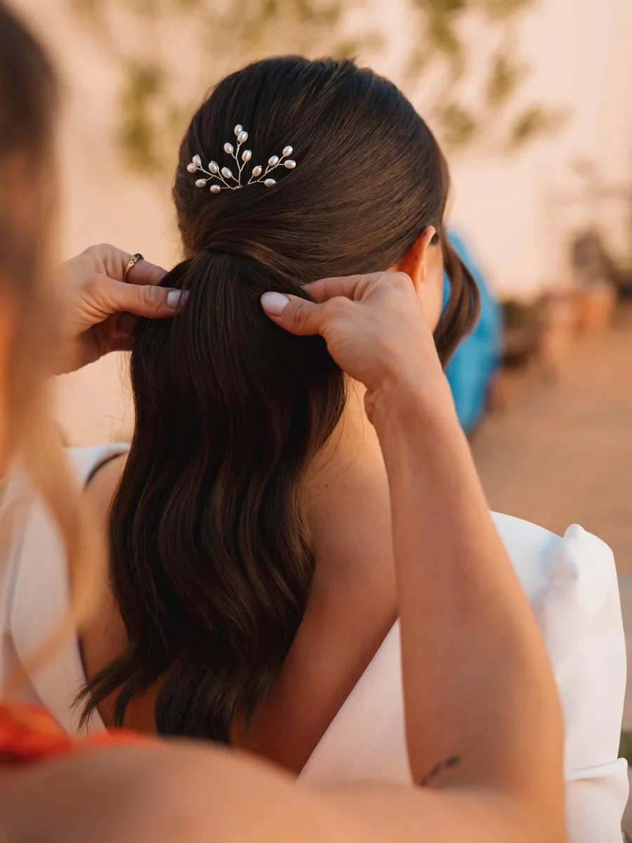 Recogido de novia con melena ondulada y pieza de perlas